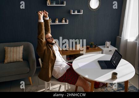 Tired nerd working online from home office Stock Photo