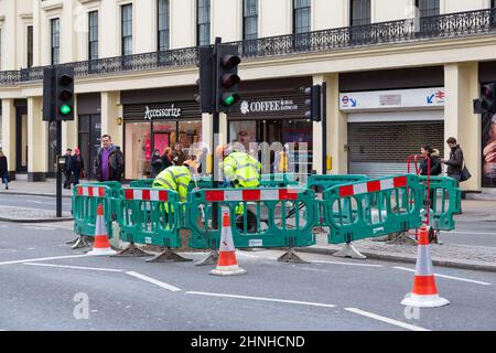 Roadworks with workforce digging, traffic lights and cones, barriers, london, uk Stock Photo