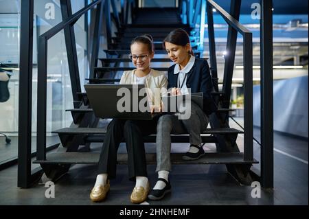 Two business children working together on stairs Stock Photo
