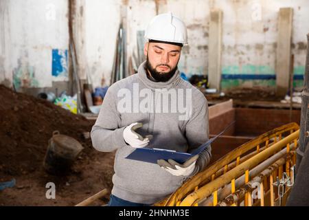 Foreman making task list during building works Stock Photo