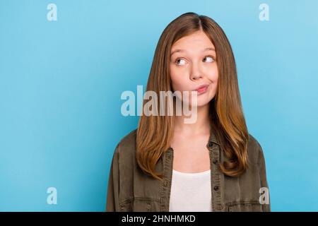 Photo of young hesitant small lady look blank space brainstorming displeased dislike isolated on blue color background Stock Photo