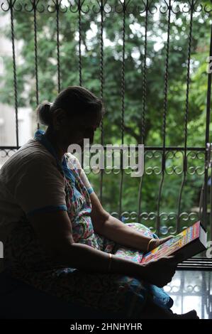 Mumbai Maharashtra India Asia June 28 2021 Silhouette Indian hindu old woman reading holy book Bhagavad Gita. Stock Photo