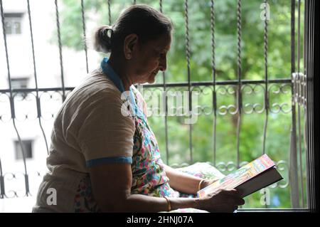 Mumbai Maharashtra India Asia June 28 2021 Indian hindu old woman reading holy book Bhagavad Gita. Stock Photo