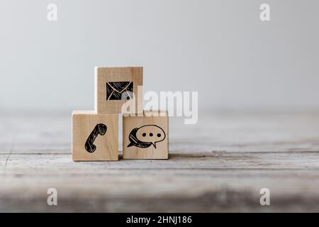 Website contact concept. Wooden block cube symbol telephone, mail, address on a wood table Stock Photo