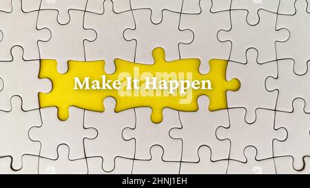 Make it happen text on yellow cover surrounded with missing white puzzle. Business concept Stock Photo