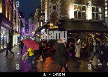 London, UK, 16 February 2022: On Carnaby Street in Soho people are shopping, browsing, eating and drinnking despite the rainy weather. During the English February half term London has seen a rise in visitors and an economic bounce-back after the pandemic is good news for shops, pubs and restaurants. Anna Watson/Alamy Live News Stock Photo