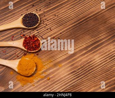 Dry different spices in spoons on wooden background Stock Photo
