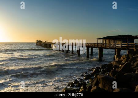 Old long wooden jetty at sunset Stock Photo