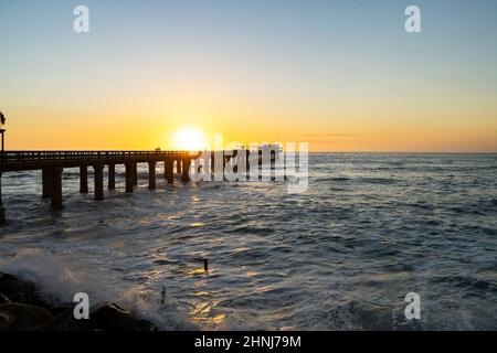 Old long wooden jetty at sunset Stock Photo