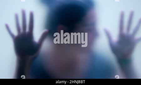 Woman behind matte glass blurry hand and body depression concept Stock Photo