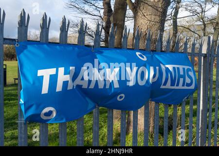 A banner reads, 'Thank you NHS' on park railings opposite the entrance to The Freeman Hospital, Newcastle upon Tyne, UK. Stock Photo