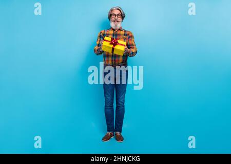 Photo of impressed man pensioner dressed checkered shirt glasses getting gift box isolated blue color background Stock Photo