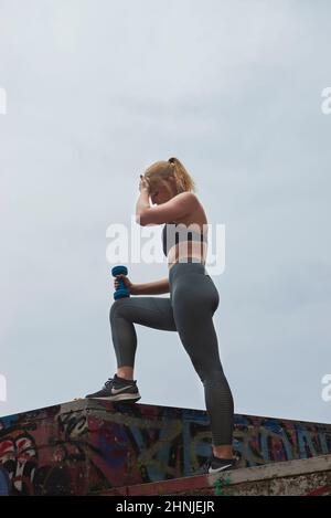 Young blonde blue eyed woman training and exercising outside