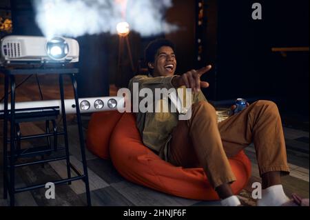 Happy young man laughing during watch film Stock Photo