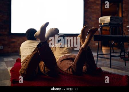 Family couple looking at blank projector screen Stock Photo