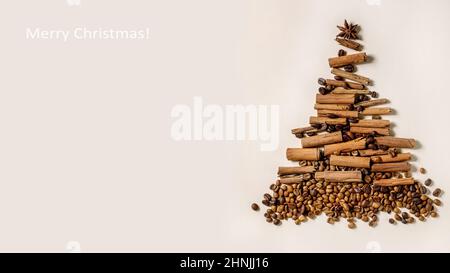 Aromatic spices cinnamon sticks and different coffee beans as Christmas tree shape over beige paper background. Xmas greetings coffee lovers. Banner s Stock Photo