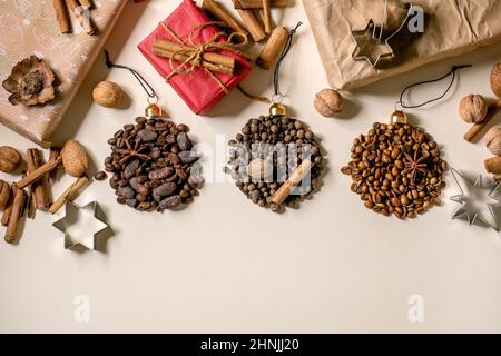 Aromatic spices collection and different coffee beans as Christmas balls shape and eco-friendly Christmas gift boxes over beige paper background. Xmas Stock Photo