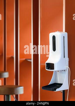 Stand automatic alcohol dispenser spraying with automatic body thermometer check temperature for covid-19 pandemic for safety before entering the coff Stock Photo