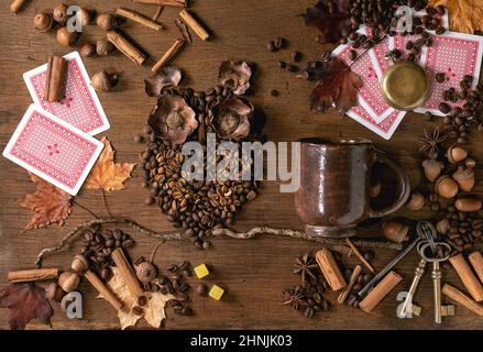 Owl shape from coffee beans and spices. Owl sit on the branch with coffee cup, playing cards, dice over wooden background. Funny mystery coffee predic Stock Photo