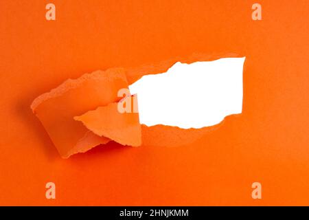 Torn hole paper orange color with copy space for text hallowen Stock Photo
