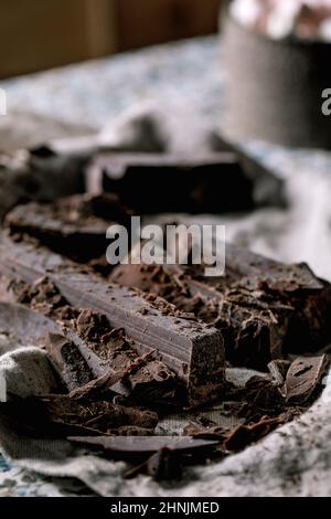 Ingredients for make hot chocolate winter drink. Chopped dark chocolate, species, cane sugar, marshmallows on rustic linen tablecloth in country kitch Stock Photo