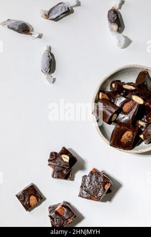 Homemade toffee salted caramel chocolate almond nuts candy on white table. Handmade food sweet gifts for any holidays. Flat lay Stock Photo