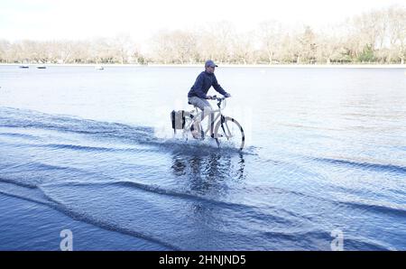 A cyclist goes through flood water by the river Thames at Putney, London after Storm Dudley hit on Thursday night. Picture date: Thursday February 17, 2022. Stock Photo