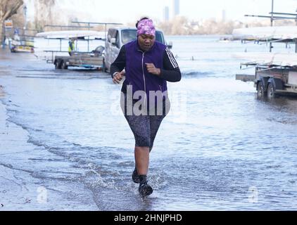 A jogger goes through flood water by the river Thames at Putney, London after Storm Dudley hit on Thursday night. Picture date: Thursday February 17, 2022. Stock Photo