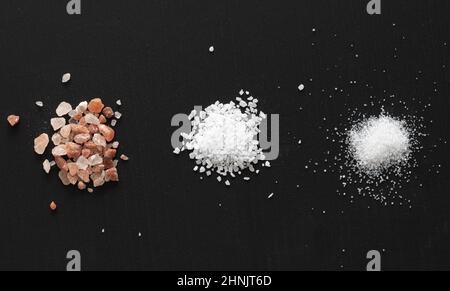 Pink Himalaya Salt, Course Salt, and Table Salt on Black Background Stock Photo