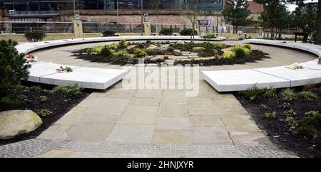 Manchester, UK, 17th February, 2022.  A man (right) looks at the Glade of Light memorial: a white marble ‘halo’ bearing the names of those killed in the 22nd May 2017 bombing. The Manchester Arena Inquiry has heard that MI5 had intelligence to assess Salman Abedi as a threat to national security and open an investigation before he carried out the bombing on 22nd May 2017, killing 22 people and injuring hundreds. Credit: Terry Waller/Alamy Live News Stock Photo