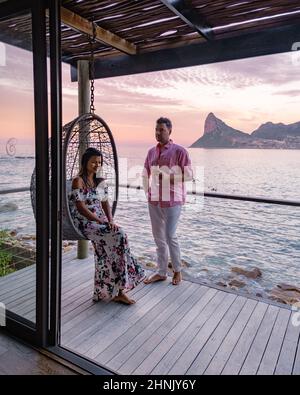 couple man and women drinking coffee during on balcony sunrise at vacation in Cape Town South Africa.  Stock Photo