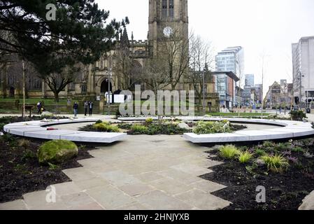 Manchester, UK, 17th February, 2022.  People look at the Glade of Light memorial: a white marble ‘halo’ bearing the names of those killed in the 22nd May 2017 bombing. Manchester Cathedral in the background. The Manchester Arena Inquiry has heard that MI5 had intelligence to assess Salman Abedi as a threat to national security and open an investigation before he carried out the bombing on 22nd May 2017, killing 22 people and injuring hundreds. Credit: Terry Waller/Alamy Live News Stock Photo