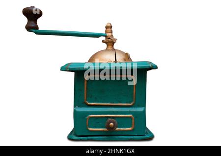 Old manual coffee grinder painted gold and green. Selective focus Stock Photo