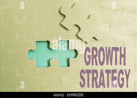 Text sign showing Growth Strategy. Business concept The method a company uses to expand its business or market Building An Unfinished White Jigsaw Pattern Puzzle With Missing Last Piece Stock Photo