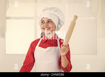 smiling teen girl in chef uniform cooking and baking, bakery Stock Photo