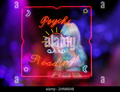 Tarot Card Readings Neon Sign in Window with Psychic Tarot Card Reader in background Stock Photo