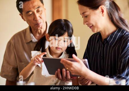 Japanese Grandparents And Grandchildren Using Tablet Devices Stock Photo