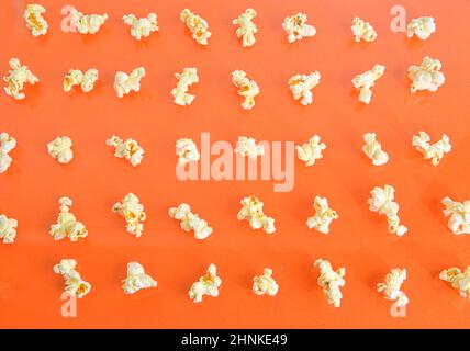 Popcorn on orange background. Movie background. Top view or flat lay. Popcorn on a pastel orange background, top view. Cinema Concept. Flat lay. Stock Photo