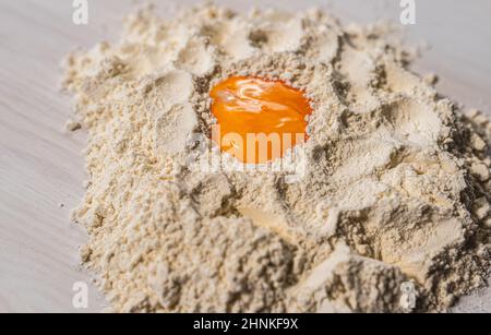 yolk in flour. egg yolk in flour, dough preparation, for noodles Stock Photo