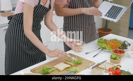 couple husband and wife cooking food vegetable salad in kitchen together at home Stock Photo