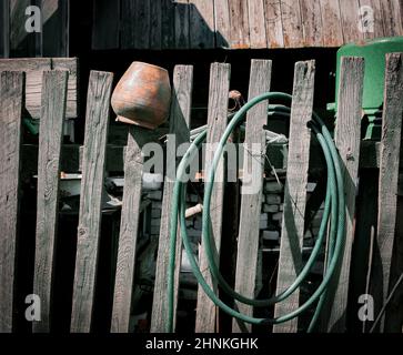 An old clay pot on the wooden fence Stock Photo