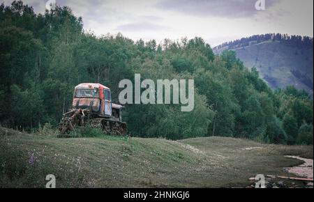 An old crawler tractor in rural landscape Stock Photo