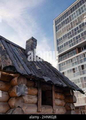 wooden hut on the background of multi-storey building Stock Photo