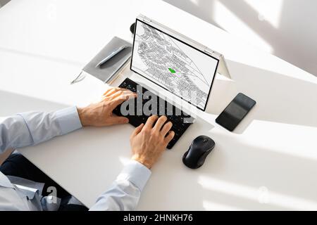 Businessperson Analyzing Cadastre Map On Computer In The Office Stock Photo