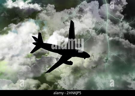 An airplane with lightning strike on the dark cloudy sky. Stock Photo