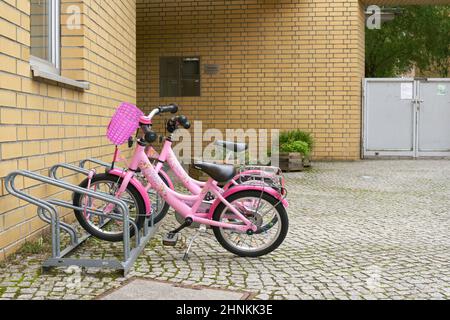 parked children bicycles waiting in front of a kindergarten in Berlin Stock Photo