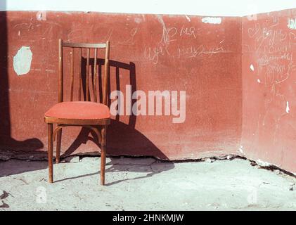An old used vintage armchair on the wall background Stock Photo