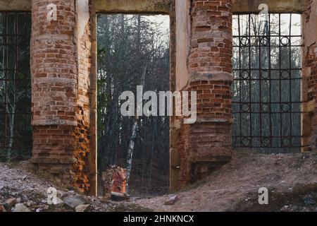 Way through brick wall of old ruined building Stock Photo