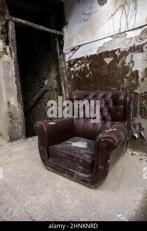 Old abandoned leather armchair Stock Photo