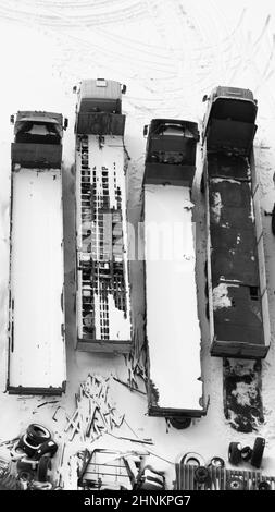 Truck under the snow. lorry covered with snow after snowfall. long trucks stand in a row aerial view. transportation concept. snow covered vehicles. copy space Stock Photo